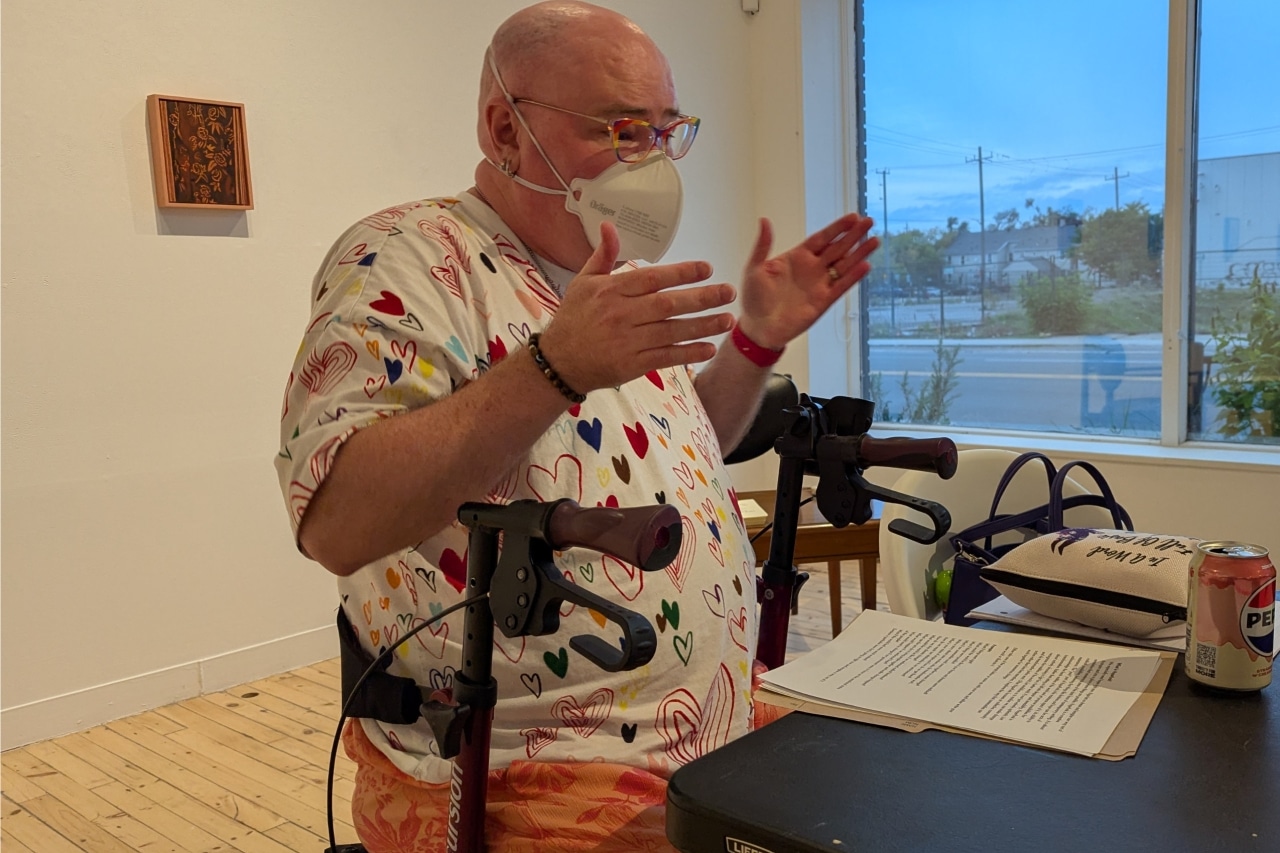 Derek Newman-Stille, seated in a walker, leads a writing workshop as part of Peterborough-Nogojiwanong Pride 2025.